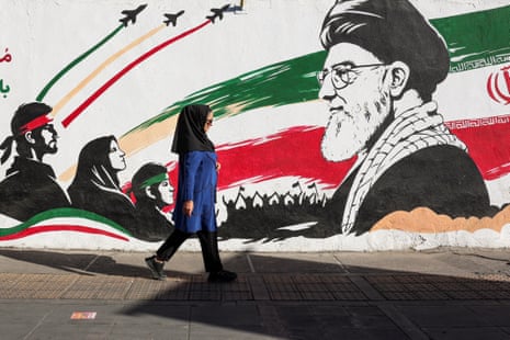 An Iranian woman walks past a mural of Iran's slain supreme leader Ayatollah Ali Khamenei in Tehran on September 23, 2026.