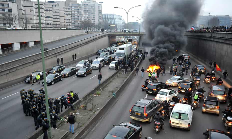 Taxi drivers demonstrate by blocking traffic and burning tyres on a ring road in Paris