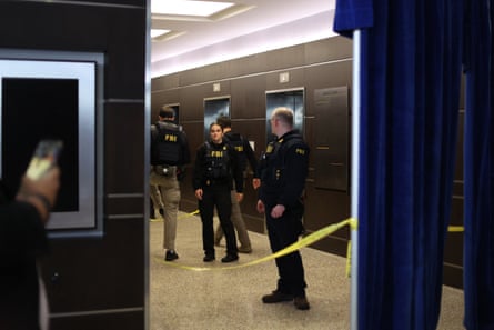 FBI agents dressed in bullet-proof vests cordon off an area of the hotel by the lifts