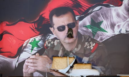 A sandal is inserted into a poster of Bashar al-Assad in Damascus on 15 December.