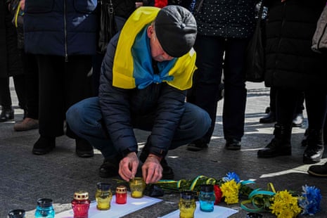 A man lights a candle during a commemorative event to mark the first anniversary of the bombing of the Mariupol Drama Theatre, held in the western Ukrainian city of Lviv.