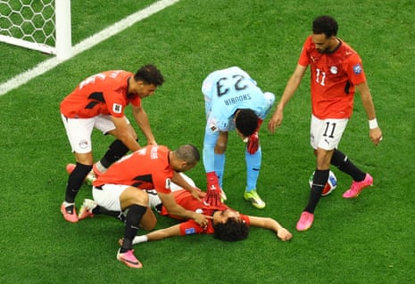 Egpyt players stand around Mohamed Hany as he lies on the ground after sustaining an injury.
