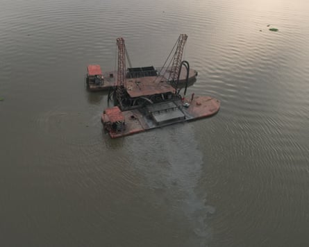 ‘The water is no longer our friend’: how dredging is pushing Lagos Lagoon towards ecosystem collapse – photo essay Drone view of a dredging barge in still waters with a plume of sediment spreading out from one side of it.