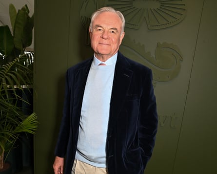 Koos Bekker: he is in his 70s with white hair, and wears a dark blue jacket, pale blue shirt, light sand trousers.