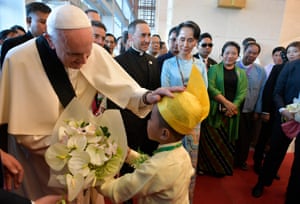 Pope Francis greeting a child as Myanmar’s civilian leader Aung San Suu Kyi watches on during an event in Naypyidaw on 28 November