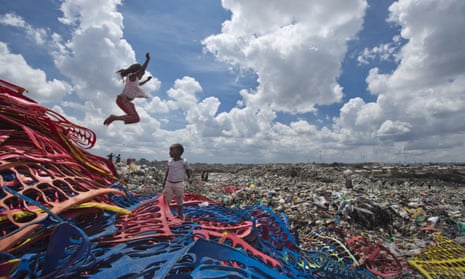 Children play on plastic left over from the manufacture of flip-flops at a dump in the Dandora slum of Nairobi, Kenya.
