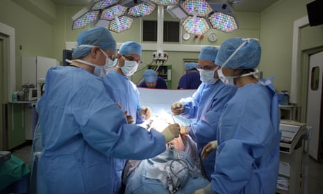 A surgeon and theatre team performing key hole surgery.
