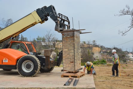 crew stands by as machinery hovers above chimney