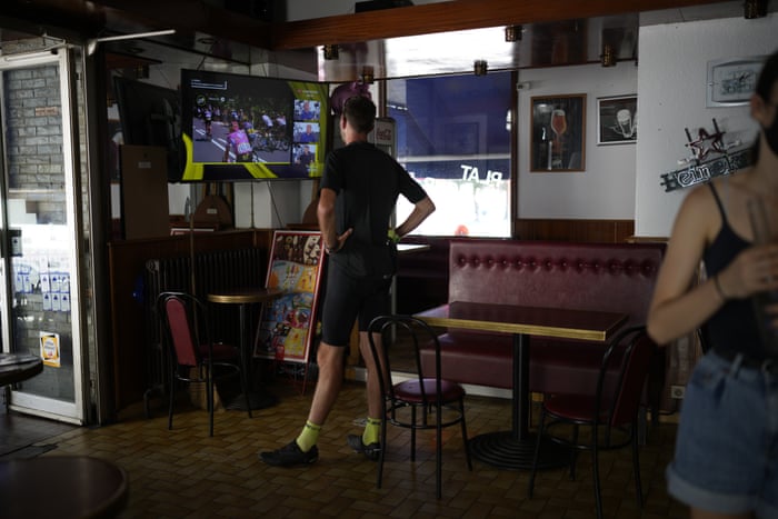 A cyclist watches live coverage of the race in a bar in Vizille.