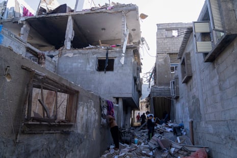 Palestinians inspect a damaged building following Israeli airstrikes on the town of Khan Younis, Gaza, on 3 December 2023.