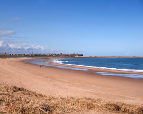 Sandhaven beach, South Shields: a wide sandy beach curves along blue water, with a town skyline visible