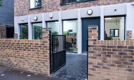 The outside wall and front gate stands in front of the modern exterior of the ELBWO building.