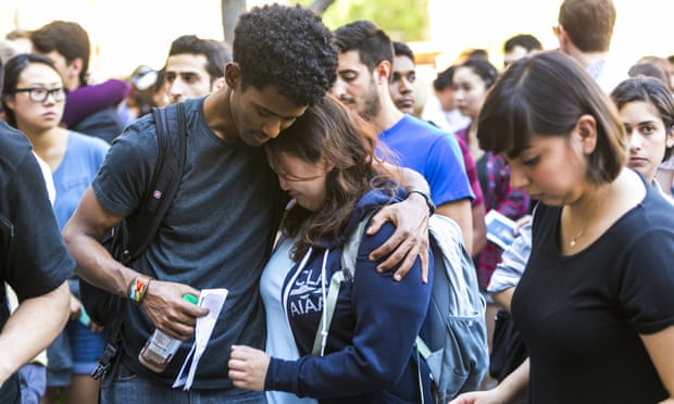 Students hug during a vigil to remember William S Klug in Los Angeles Friday.
