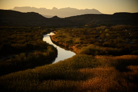 A river winds between mountain ranges