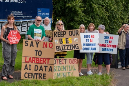 People hold signs with messages including ‘keep our bees buzzing’, ‘protect our residential amenity’ and ‘defo no to AI in bonnie Scotland’.