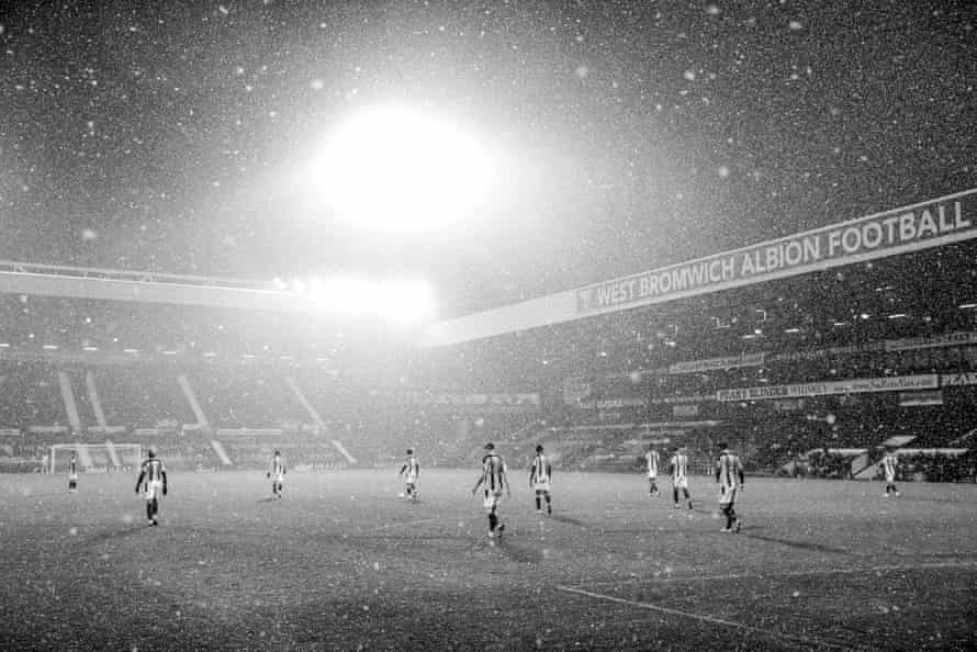 As heavy snow falls, all ten outfield West Brom players trudge back to the centre circle after conceding the second goal in their 4-0 defeat to Arsenal.