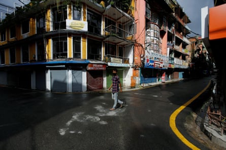 A man walks along empty streets in Thamel, Kathmandu. Once a major tourist hub, the area is deserted and shops are closed after the government imposed restrictions on travel and gatherings to prevent the spread of Covid.