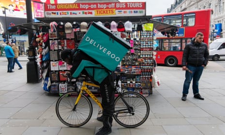 A Deliveroo courier bag cycles through Piccadilly Circus.