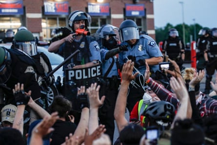 A police officer points a hand cannon at protesters on South Washington Street in Minneapolis, Minnesota, in May 2020.