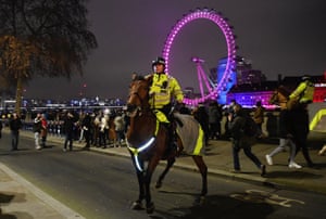 Police try to encourage people to go home on New Year’s Eve in London.