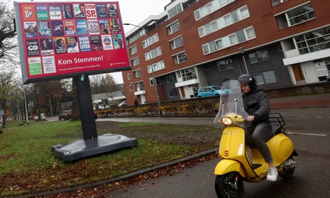 A person rides past election campaign posters on a hoarding in Breda