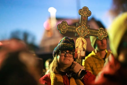 Woman holds cross at protest