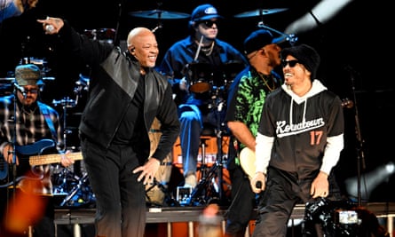 two men wearing black smile on stage as they perform