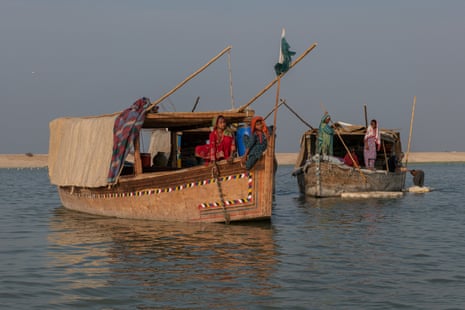 Two boats with the back halves shaded by a low, flat roof covered with canvas hangings