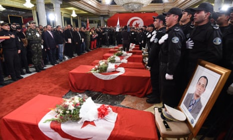 Tunisian police and mourners gather around the coffins of the presidential guards killed in the suicide bombing.