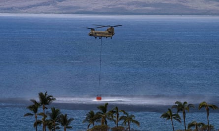 helicopter picking up water for fire fighting