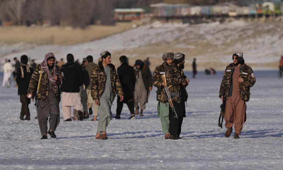 Taliban fighters walk at the frozen Qargha Lake, near Kabul, Afghanistan.