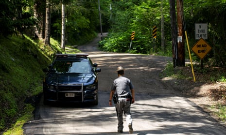 A New York State Trooper stands guard outside the home where attorney Roy Den Hollander was found dead in Catskills, New York Monday.