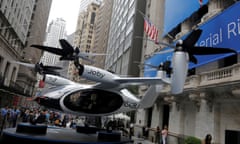 an air taxi on display on a street with tall buildings