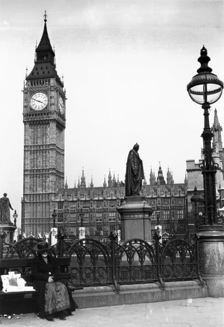 Old woman sitting on a bench in front of Big Ben, 1920s.