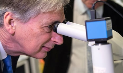 Britain’s Finance Secretary Philip Hammond uses a microscope to examine protein crystals during his visit to The Francis Crick Institute in London last week.
