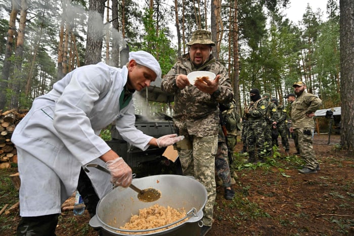 Territorial defence troops have dinner outside the Ukrainian town of Bucha, near Kyiv.