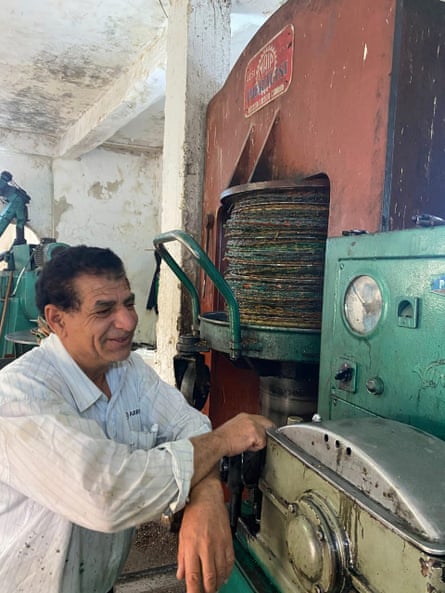 A man prepares to push a lever as he presses olives in Jordan.
