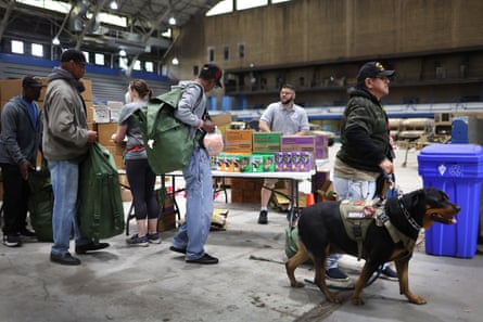veterans line up in front of a table with food at an event for services for veterans experiencing homelessness