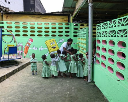 A teacher surrounded by a group of children at a nursery in Abidjan, Ivory Coast