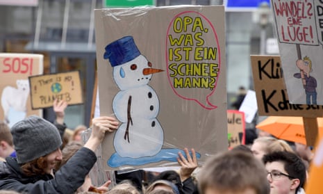 A student holds a placard reading “Grandpa, what is a snowman?”