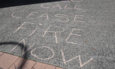 Chalk writing on the ground that reads 'Call ceasefire now'