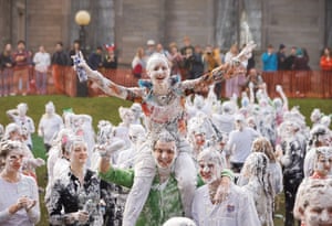 Students covered in white foam celebrating on a college lawn