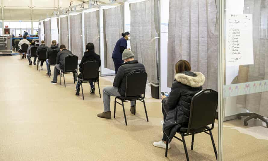 People wait to be called into a cubicle to receive a Covid-10 vaccine at the Melbourne Showgrounds vaccination centre