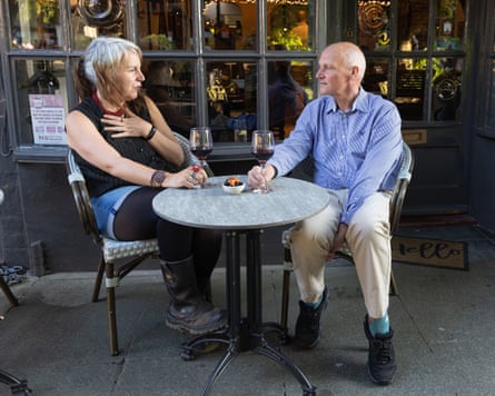Becky and Andy sitting chatting at a small table outside the front of a restaurant