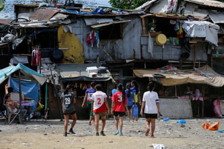 Members of the Philippines team walk through a slum area to their dormitory, after a training session in Payatas, Quezon City, north of Manila