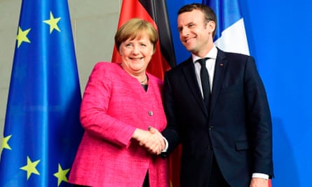 Angela Merkel and Emmanuel Macron shake hands after the new French president took office.
