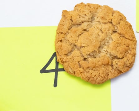 A golden Anzac biscuit on a yellow post-it note with the number “four” written on it.