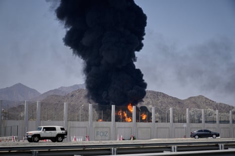 फुजैराह के बंदरगाह पर आग और काले धुएं का बादल।