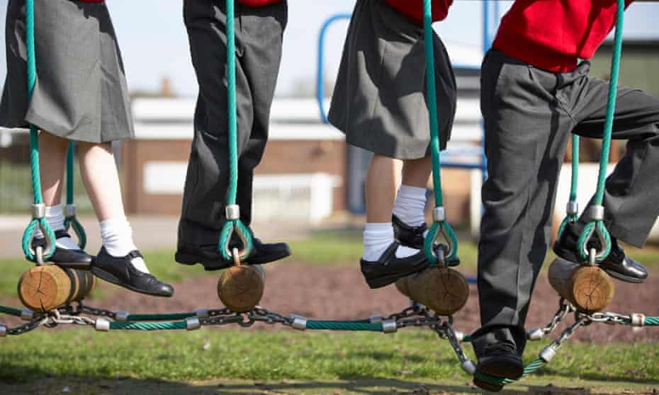 Young schoolchildren playing on a rope ladder