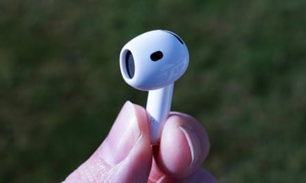An Apple AirPods 4 earbud held between finger and thumb.